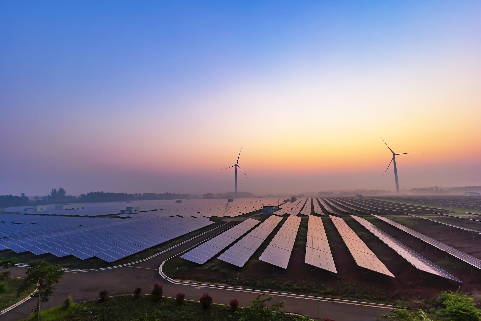 Panneaux solaires et éoliennes au coucher du soleil - la bellenergie