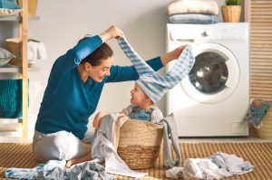Mère avec son fils jouant près de la machine à laver le linge - la bellenergie