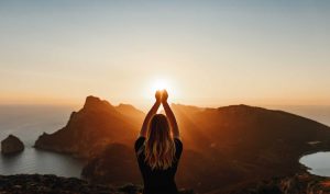 Femme attrapant les rayon du soleil entre ses mains - la bellenergie