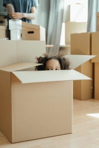 Petite fille dans un carton de Déménagement