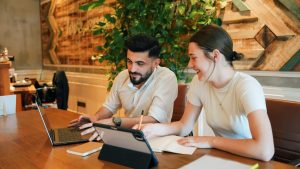 Deux collègues de travail sont dans un open space. Ils travaillent tout en réduisant leur emprunte carbone.