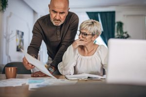 Homme et femme observant leur facture d'électricité inquiets