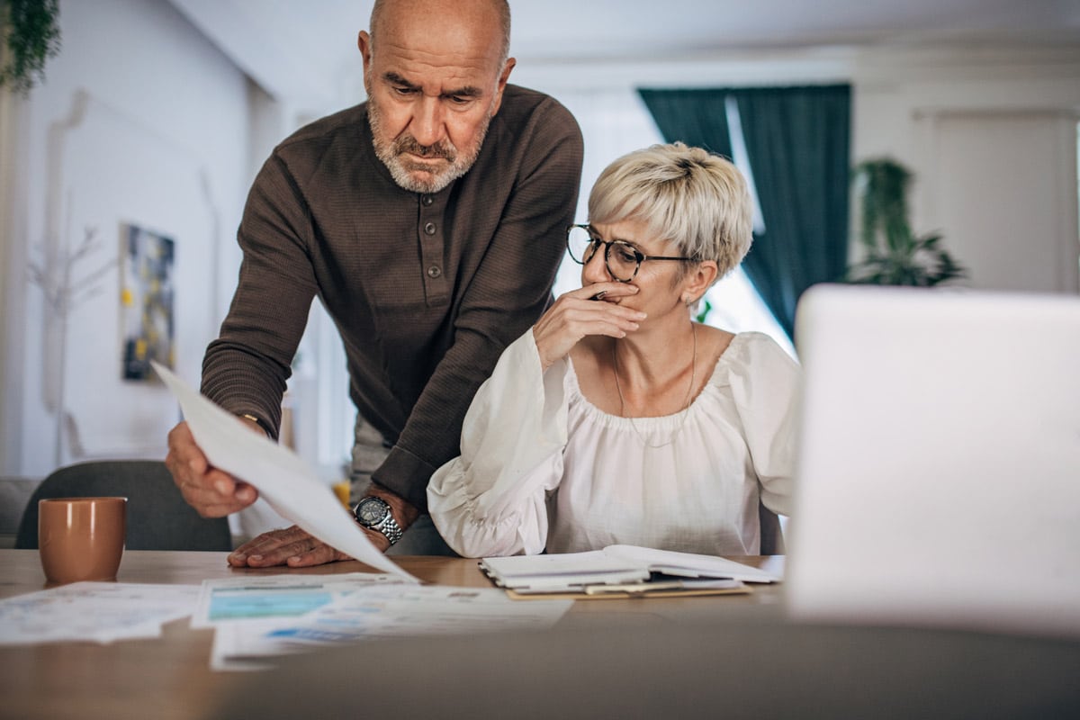Homme et femme observant leur facture d'électricité inquiets